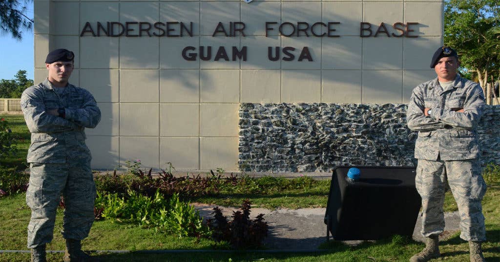 Two Airmen stand with too much pride in front of Andersen Air Force Base. (Source: DoD)