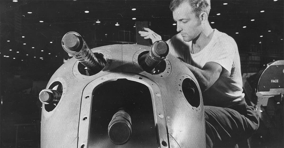 An armorer's assistant in a large western aircraft plant works on the installation of one of the machine guns in the nose position of a new Lockheed P-38 pursuit plane. (Photo from U.S. National Archives)