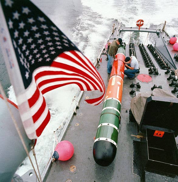 US Navy torpedo retrievers secure a Mark 48 to the deck of their boat (Photo US Navy)