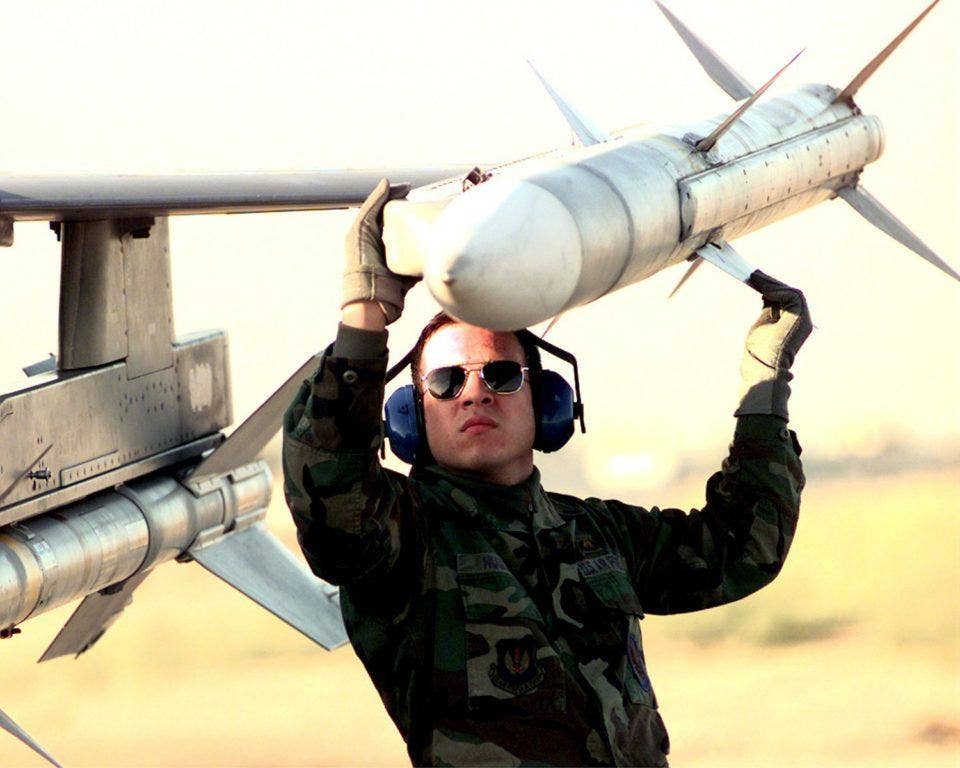 An AIM-120 AMRAAM being loaded onto an F-16CJ. | US Air Force
