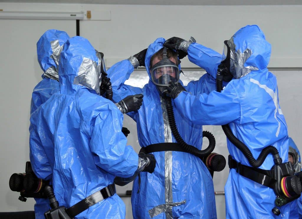 Members of the 151st Air Refueling Wing Medical Group don their hazardous material suits for training at Camp Williams, Utah. (U.S. Air Force photo by Tech. Sgt. Jeremy Giacoletto-Stegall)