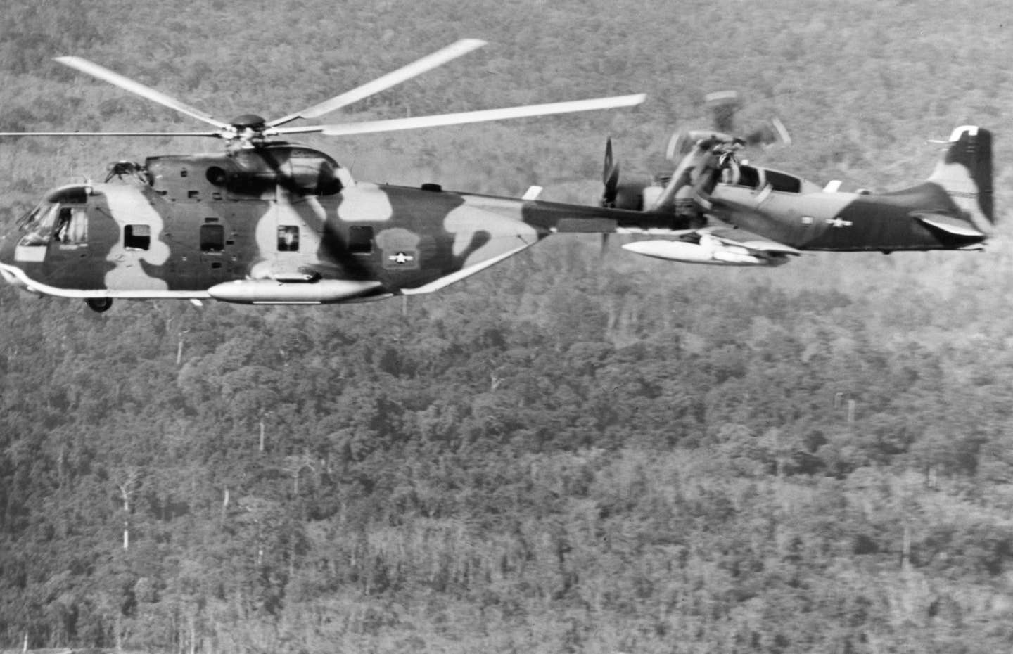 a-1 skyraider escorting a helicopter