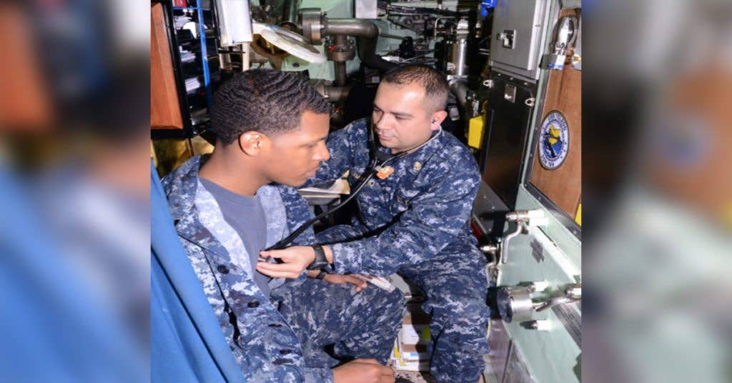 Chief Hospital Corpsman Reyes Camacho, right, checks the heartbeat of Machinist's Mate 3rd Class Rudy Taylor, left, aboard the Los Angeles class attack submarine USS Toledo (SSN 769), Dec. 15. Submarine Force Independent Duty Corpsmen are the sole medical professionals permanently assigned to submarine crews. (Navy photo/Mass Communication Specialist 1st Class Bill Larned)