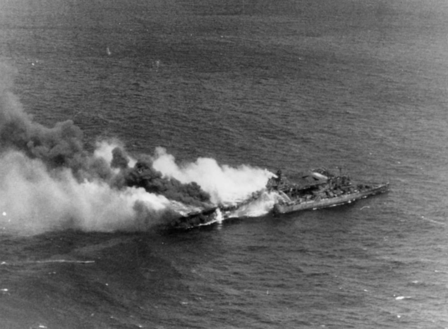 The U.S. aircraft carrier USS Franklin (CV-13) pictured burning in the waters off Japan after being hit during an air attack on March 19, 1945. The light cruiser USS Santa Fe (CL-60) is alongside. (US Navy photo)