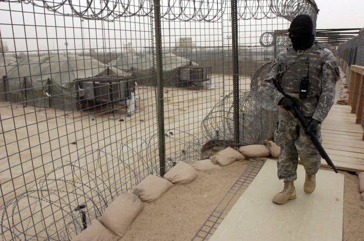 Sgt. Adonis Francisco, Alpha Company, 2-113th Infantry Battalion, patrols along a catwalk at the Camp Bucca Theater Internment Facility, the largest detention center in Iraq. (U.S. Army photo)