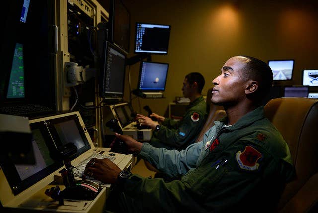 Maj. Bishane, a 432nd Aircraft Maintenance Squadron MQ-9 Reaper pilot, controls an aircraft from Creech Air Force Base, Nevada. RPA personnel deal with the stressors of deployed service members while maintaining the normalcy of their day-to-day lives through programs designed to enhance communication skills, family and spiritual growth. (U.S. Air Force photo/Staff Sgt. Vernon Young Jr.)