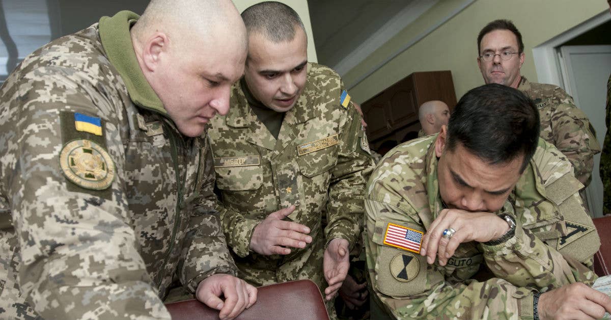Brig. Gen. Tony Aguto, commander for the 7th Army Training Command, reviews engineering plans for the International Peacekeeping and Security Center, Near Yavoriv, Ukraine, with IPSC Commander Ukrainian army Col. Igor Slisarchuk, ISPC commander (left). Photo by Sgt. Anthony Jones.