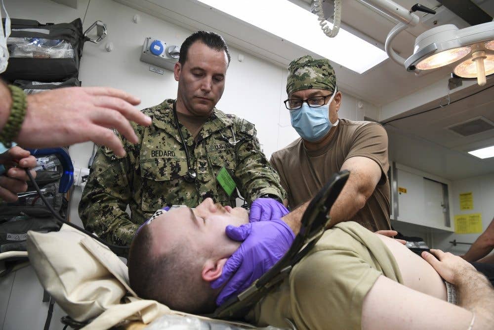 Capt. Robert Jacoby, right, and Hospital Corpsman 1st Class Raymond Bedard, from Expeditionary Resuscitative Surgical System 19, prepare medical supplies aboard Royal Fleet Auxiliary ship Cardigan Bay. (U.S. Navy photo by Mass Communication Specialist 2nd Class Kevin J. Steinberg/Released)