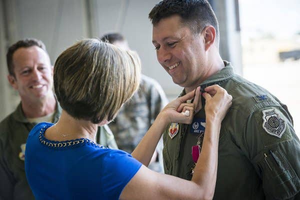 Veronica Ballek, wife of Col. Michael Ballek, pins a retirement pin on her husband during his retirement ceremony at Mountain Home Air Force Base, Idaho, June 2, 2015. | US Air Force photo by Tech. Sgt. Samuel Morse