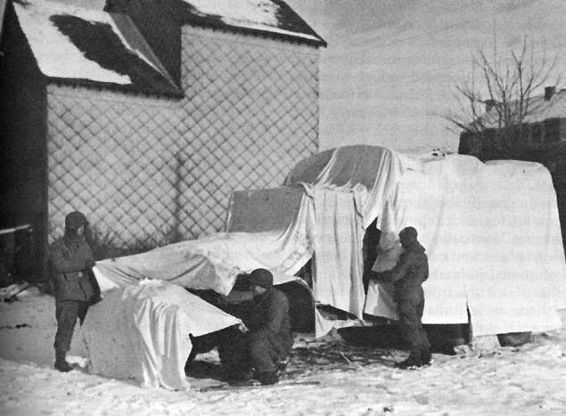 Soldiers use bedsheets donated by the locals to hide military equipment from Luftwaffe bombers and German army artillery. Photo: US Army