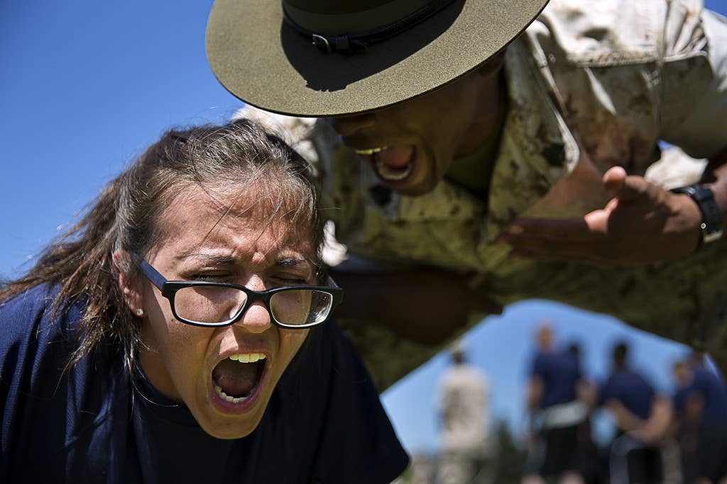 Miekha Dowling, a prospective Marine enlistee from Lakewood, Wash., responds to guidance from Sgt. Julian Taylor, a drill instructor from Marine Corps Recruit Depot San Diego, during a Recruiting Station Seattle pool function at the Yakima Training Center in Yakima, Wash., July 17, 2015. During the event, recruiters teamed with drill instructors to physically and mentally prepare enlistees from Washington and Idaho for boot camp. The enlistees, part of the Marine Corps delayed entry program, are awaiting their ship dates. Dowling, 16, attends Lakes High School in Lakewood. Taylor, 26, is from St. Augustine, Fla., and is assigned to Lima Company, 3rd Recruit Training Battalion. (U.S Marine Corps photo by Sgt. Reece Lodder)