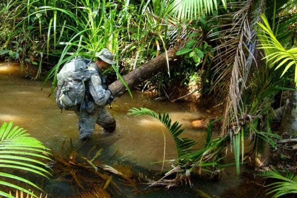 A U.S. Soldier crosses a stream during the 12-day Australian Army Junior Leader Jungle Training Course last year in Australia. | US Army photo
