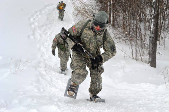 A 10th Mountain Division (Light Infantry) Soldier uses snowshoes to charge up a hill during a portion of the Mountain Winter Challenge competition, held Jan. 28-30, 2014, at Fort Drum, N.Y. (U.S. Army photo by Staff Sgt. Joel Pena)
