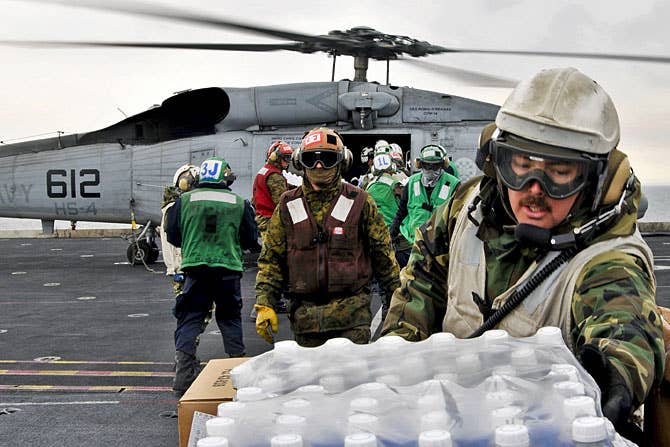 U.S. sailors and Marines aboard the aircraft carrier USS Ronald Reagan load humanitarian assistance supplies to support Operation Tomodachi. (Photo: U.S. Navy Seaman Nicholas A. Groesch)