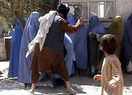 Two Taliban religious police beating a woman in public because she dared to remove her burqa in public. (Hidden camera footage courtesy of the Revolutionary Association of the Women of Afghanistan)