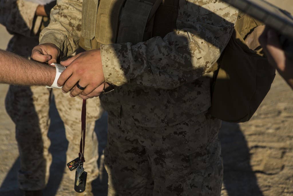 A Marine tags a confirmed role player while conducting an embassy evacuation exercise. Photo: US Marine Corps Lance Cpl. Jodson B. Graves