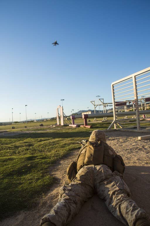 A U.S. Marine provides security during an embassy evacuation exercise while an AV-8B Harrier flies overhead. Photo: US Marine Corps Lance Cpl. Jodson B. Graves