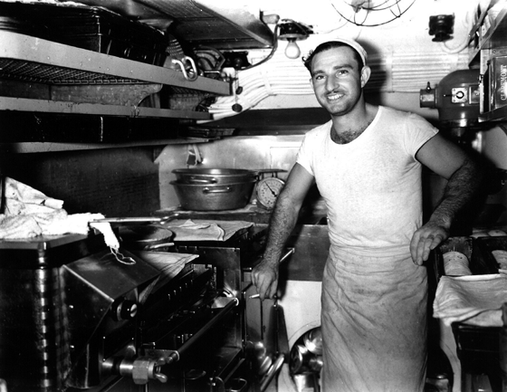 Real World War II galley attire: T-shirt and apron over dungarees. This June 1945 snapshot is of George Sacco, a cook and baker in USS Cod (SS 224). (Courtesy of the USS Cod Submarine Memorial)