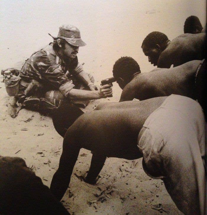 1978 - American mercenary, member of &quot;Grey's Scouts,&quot; holds gun to the head of a Rhodesian prisoner