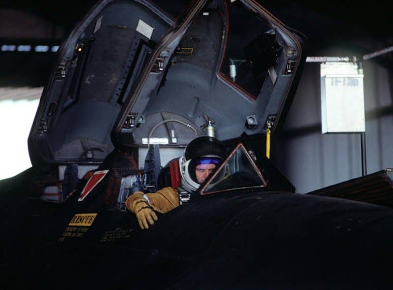 A pilot mans the brakes as the SR-71 is towed out of the hangar.