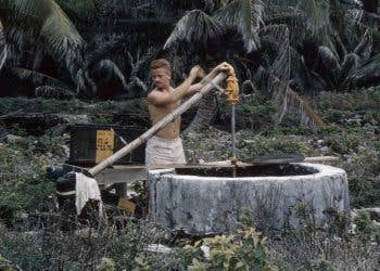 Cunningham pumps water from an old well on North Danger Island in 1956. The Airmen only used this for laundry and washing. Drinking water was delivered in 55-gallon barrels. (Courtesy photo Bob Cunningham)