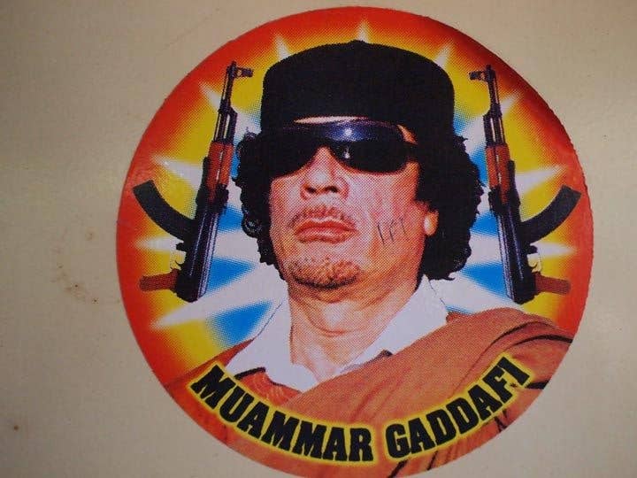 a sticker of gaddafi with two ak-47 guns