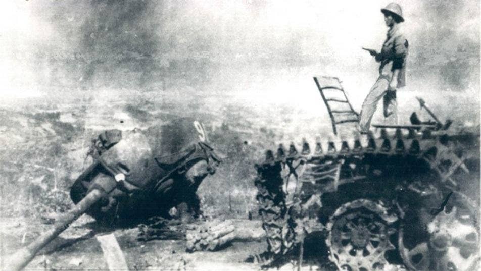 A Vietnamese military officer standing on the wreckage of a destroyed Chinese tank in Cao Bang during the Sino-Vietnamese War.