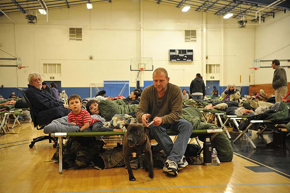 A family gets settled into an emergency shelter following the Oroville spillway evacuation notice at Beale Air Force Base, California, Feb. 13, 2017. Beale is providing evacuees with shelter, food, and water. (U.S. Air Force photo/Airman Tristan D. Viglianco)