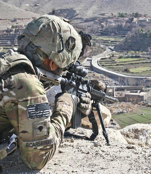 An infantryman with Company C, 1st Battalion, 133rd Infantry Regiment, Task Force Ironman, from Iowa Falls, Iowa, looks down on a spot in Tupac, Afghanistan