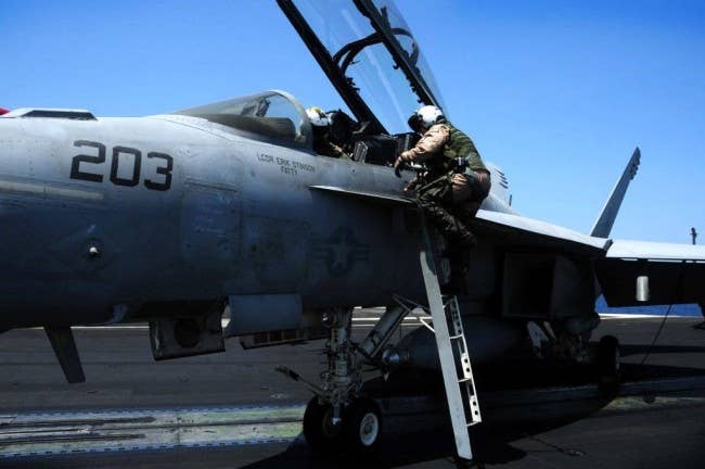 Super Hornet weapons system operator climbs into the rear cockpit of an F/A-18F Super Hornet. (Photo: U.S. Navy)