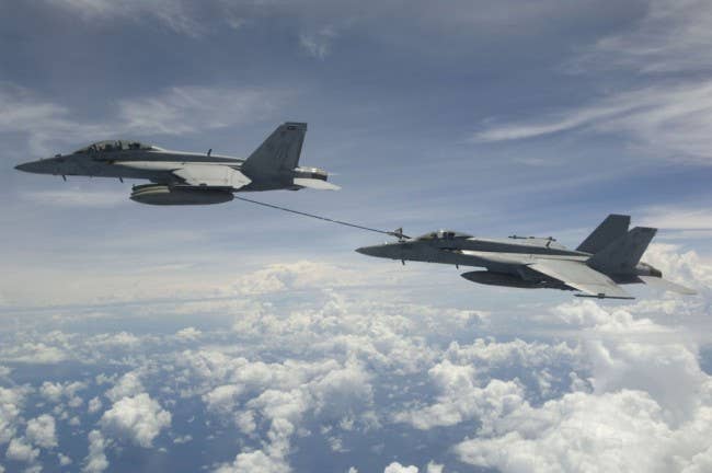 F/A-18F passes gas to an F/A-18E. (Photo: U.S. Navy)