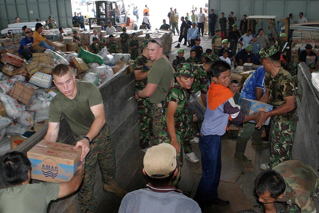 Medan, Indonesia (Jan. 4, 2005) - Marines assigned to 3rd Transportation Support Battalion, 3rd Force Service Support Group, help distribute humanitarian relief supplies at Palonia Air Field in Medan, Indonesia. Helicopters from USS Bonhomme Richard (LHD 6) and Marines assigned to 15th Marine Expeditionary Unit are supporting Operation Unified Assistance, the humanitarian operation effort in the wake of the Tsunami that struck South East Asia. The Bonhomme Richard Expeditionary Strike Group is currently operating in the Indian Ocean off the waters of Indonesia and Thailand. U.S. Marine Corps photo by Lance Cpl. Andreas A. Plaza (RELEASED)