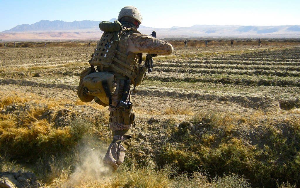 A corpsman dressed in camo rushing to the scene