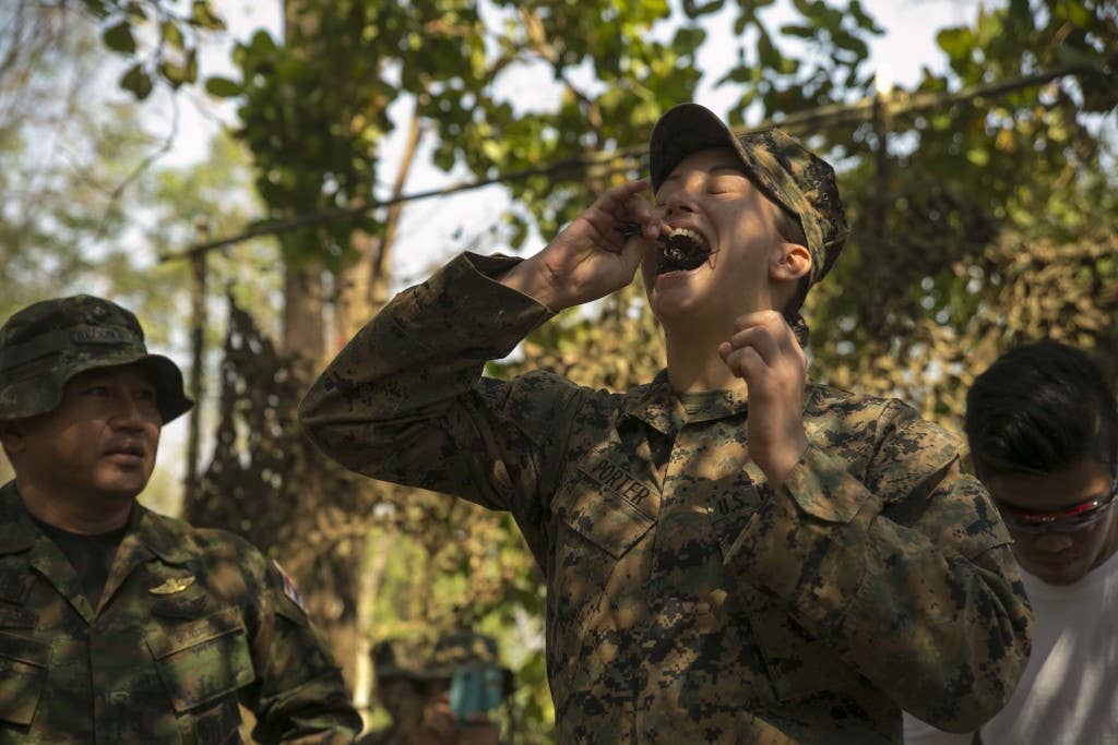 Cpl. Kyleigh M. Porter, from Montross, Va., eats a scorpion Feb. 8 in Ban Chan Krem, Thailand, during exercise Cobra Gold 2015. The Royal Thai Marines demonstrated several jungle survival tactics and asked for U.S. Marine volunteers to participate. Porter is a radio operator with Marine Air Support Squadron 2, Marine Air Control Group 18, 1st Marine Aircraft Wing, III Marine Expeditionary Force. (Marine Corps photo by Cpl. Isaac Ibarra/Released)