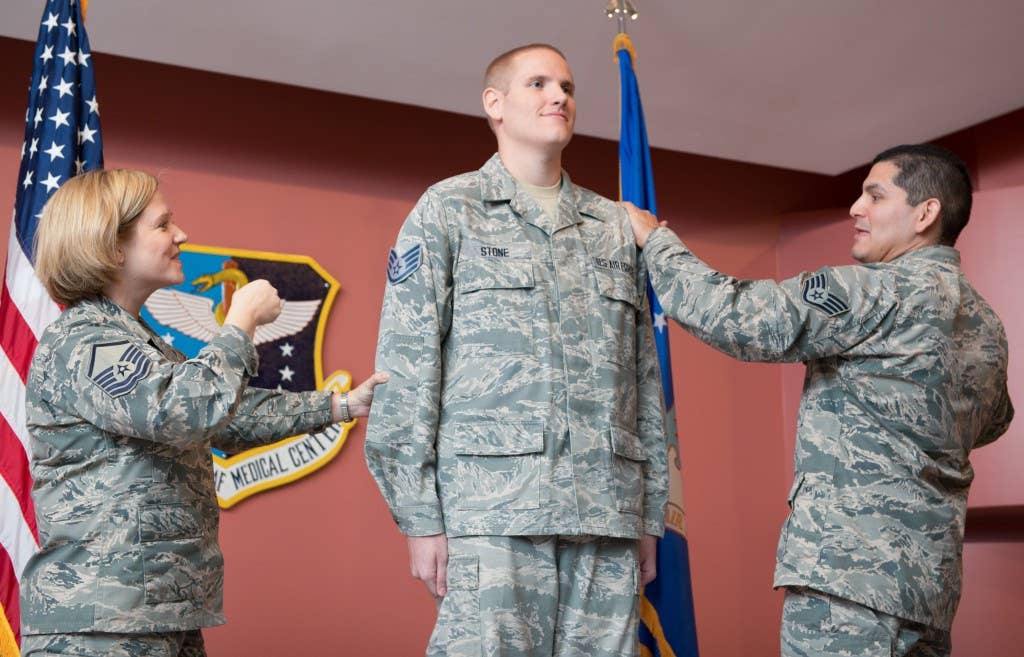 Master Sgt. Tanya Hubbard, 60th Medical Group, left, and Staff Sgt. Roberto Davila, 60th Medical Group, right, tack staff sergeant stripes on to Spencer Stone, 60th Medical Operations Squadron medical technician during a promotion ceremony at Travis Air Force Base, California, Oct. 30, 2015. Following his promotion to senior airman minutes earlier, Stone was promoted to the rank of staff sergeant by order of Air Force Chief of Staff Gen. Mark A. Welsh III. According to Air Force Instruction 36-502, the chief of staff of the Air Force has the authority to promote any enlisted member to the next higher grade. Stone became the recipient of the rare honor following his heroic actions in August when he and two friends thwarted a potential terrorist attack on a train traveling to Paris. (U.S. Air Force photo by Ken Wright)