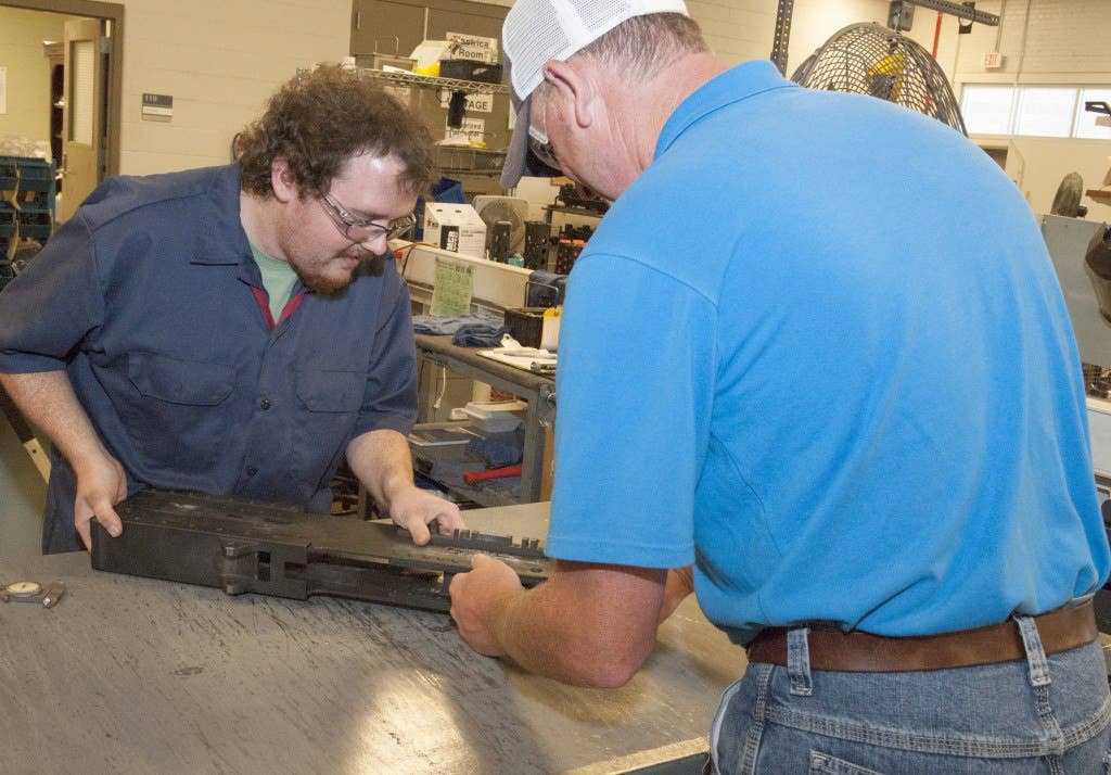 Cody Bryant, left, and Corby Tinney inspect the 324th M2 receiver ever produced. The weapon arrived at Anniston Army Depot to be converted to a M2A1 in May. Photo: Army Materiel Command Mrs. Jennifer Bacchus