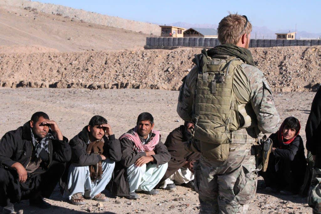 A special operations team member with Special Operations Task Force West greets new Afghan Local Police recruits on their first day of training in Farah province (U.S. Marine Corps photo by Sgt. Chadwick de Bree)