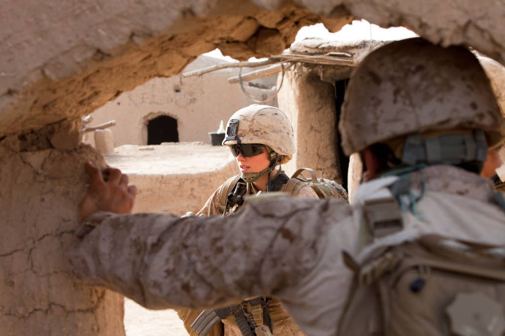 Lance Cpl. Chandra Francisco with the female engagement team in support of 1st Battalion, 5th Marines talks to Afghan women inside a compound during an operation to clear the village of Seragar in Sangin, Afghanistan. (Marine Corps photo)