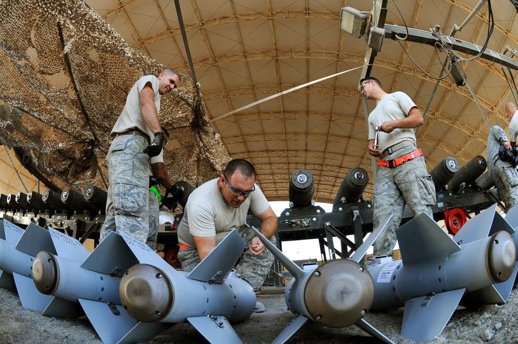 Master Sgt. Adam, middle, NCO-in-charge of conventional maintenance, preps the KMU-572 fins for assembly onto the MK-82 munition in Southwest Asia. (U.S. Air Force photo/Senior Master Sgt. Carrie Hinson)