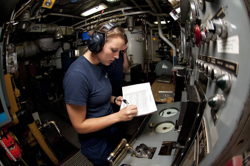 U.S. Coast Guard First Class Cadet Holly Madden logs a reading in the engine room aboard the Coast Guard Cutter Eagle. (U.S. Coast Guard photo by Petty Officer 1st Class NyxoLyno Cangemi)