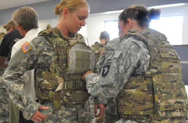 Spc. Arielle Mailloux gets some help adjusting her protoype Generation III Improved Outer Tactical Vest from Capt. Lindsey Pawlowski at Fort Campbell, Ky. (U.S. Army photo)