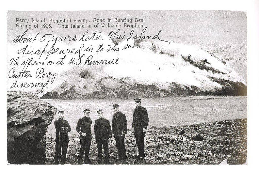 Postcard of the U.S. revenue cutter Perry poses with Perry Island behind them. Perry Island was near Bogoslof Island in the Bering Sea. It arose in a volcanic eruption in 1906, witnessed by the crew of the Perry, and sank back under the sea about 5 years later.