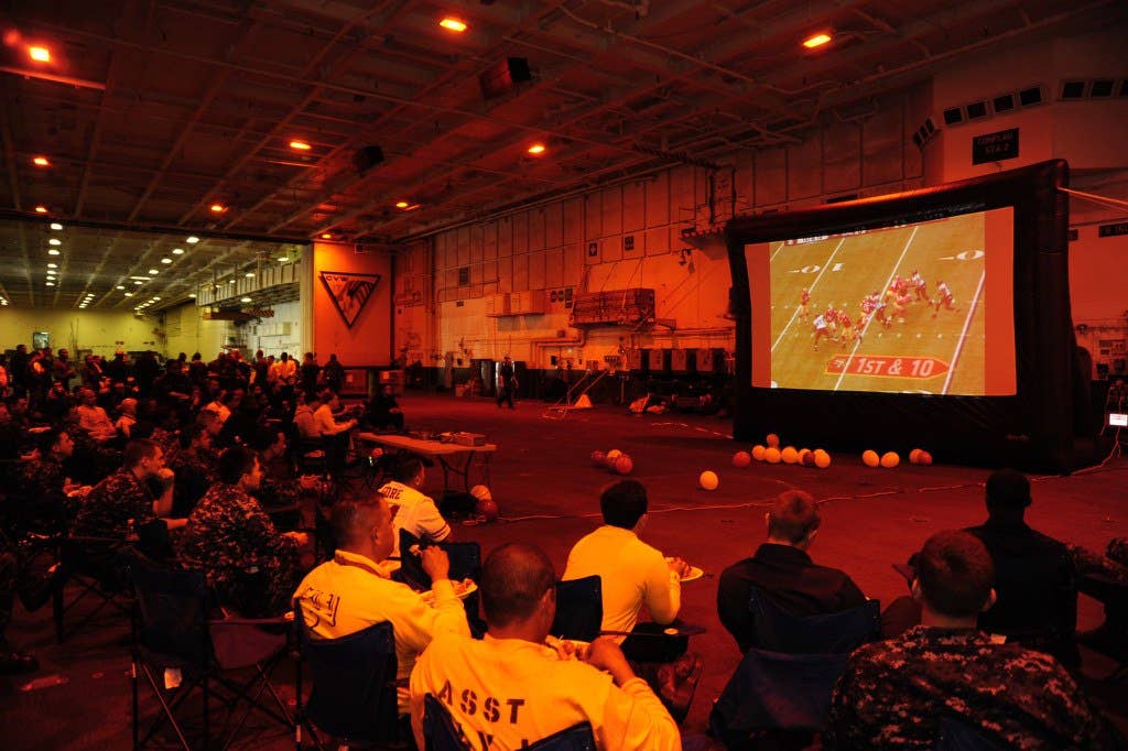 Sailors watch Super Bowl XLVII in the hangar bay aboard the aircraft carrier USS Carl Vinson (CVN 70). (U.S. Navy photo by Mass Communication Specialist 3rd Class Giovanni Squadrito)