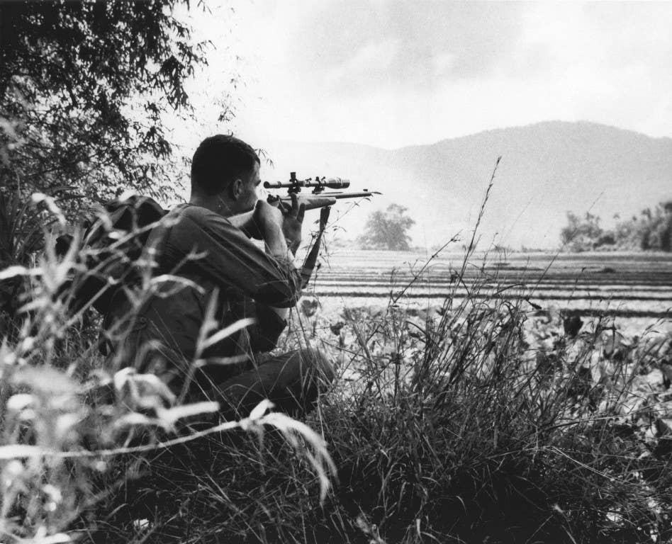 A U.S. Marine Corps sniper scans his sector through his optics in the Vietnam War. (Photo: US Marine Corps archives)