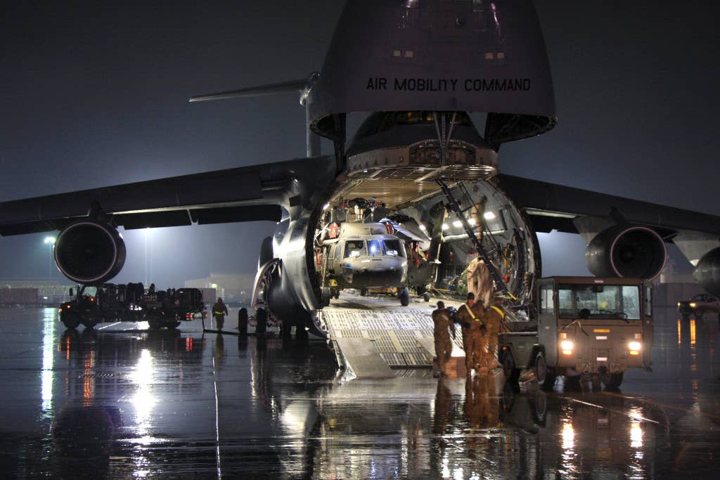 Ground crews unload a U.S. Army UH-60 Black Hawk helicopter from a U.S. Air Force C-5 Galaxy transport aircraft at Bagram Airfield, in Parwan province, Afghanistan. (U.S. Army photo by 1st Lt. Henry Chan)