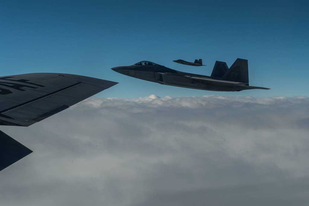 A F-22 Raptors from Tyndall Air Force Base, Fla., fly off the wing of a KC-135 Stratotanker on their way to Iraq. The F-22s are supporting the U.S. lead coalition against Da'esh. (U.S. Air Force Photo by Staff Sgt. Perry Aston)