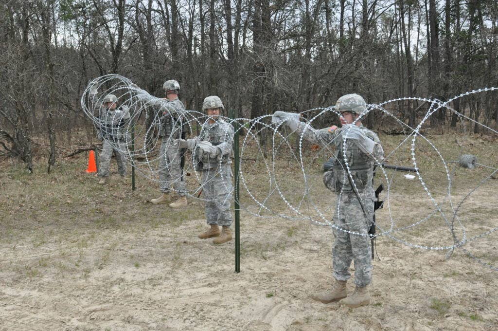 sappers putting up barbed wire