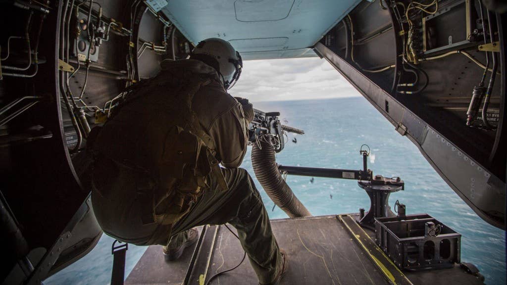 Lance Cpl. Jarod L. Smith, a crew chief with Marine Medium Tiltrotor Squadron 365, fires a mounted M2 Browning .50-caliber machine gun from the back of the MV-22B Osprey during a live fire training session off the coast of Marine Corps Air Station New River, N.C., Feb 10, 2016. Marines with VMM-365 flew to a landing zone, which allowed pilots to pratice CALs in their Osprey's and then flew several miles off the coast to practice their proficiency with the .50-caliber maching gun. (U.S. Marine Corps photo by Lance Cpl. Aaron Fiala/Released)