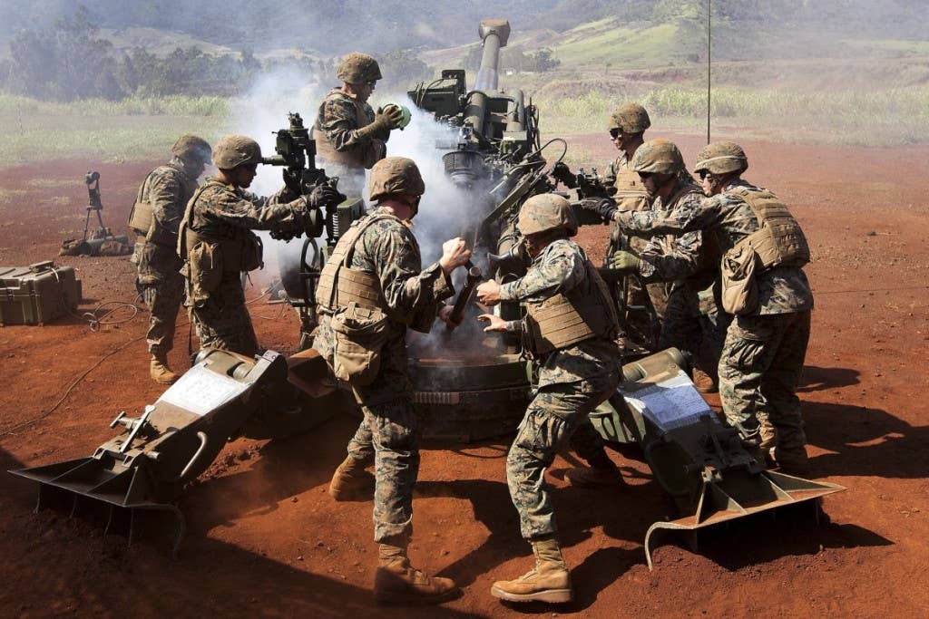 Marines with Bravo Battery, 1st Battalion, 12th Marine Regiment, hastily reload an M777 howitzer with a 155 mm artillery shell during a multiple-rounds fire mission as a part of a two-day dual-fire training exercise at Schofield Barracks, Hawaii, Nov. 13, 2013. | Photo by U.S. Marine Corps
