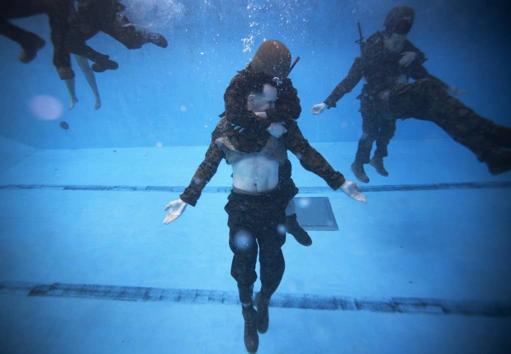 Sgt. William Wickett, 2nd Radio Battalion, performs a rescue drill during the Marine Corps Instructor of Water Survival Course at Marine Corps Base Camp Johnson, N.C., March 5, 2013. | Photo by U.S. Marine Corps